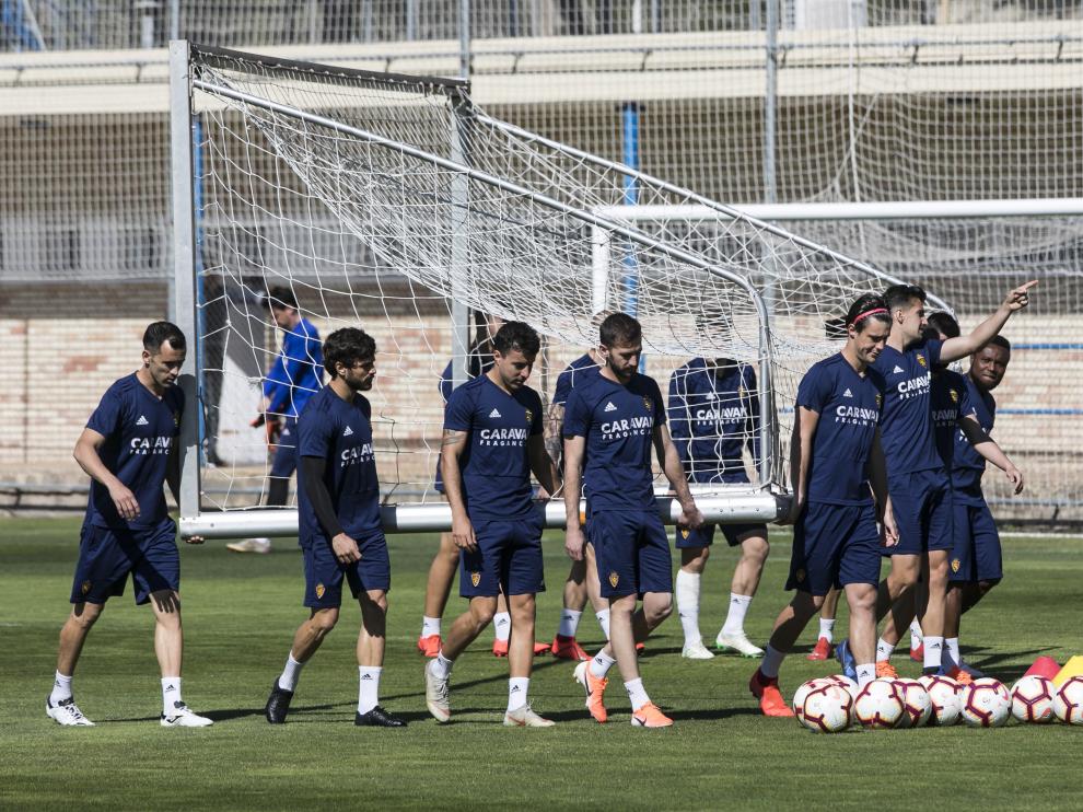 Los jugadores del Zaragoza trasladan una portería en el entrenamiento de ayer.