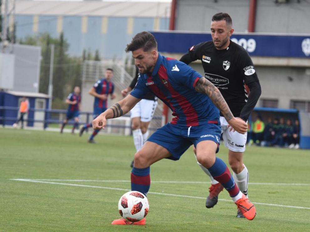 Un jugador del Levante B defiende ante la presión de un rival del CD Ebro.
