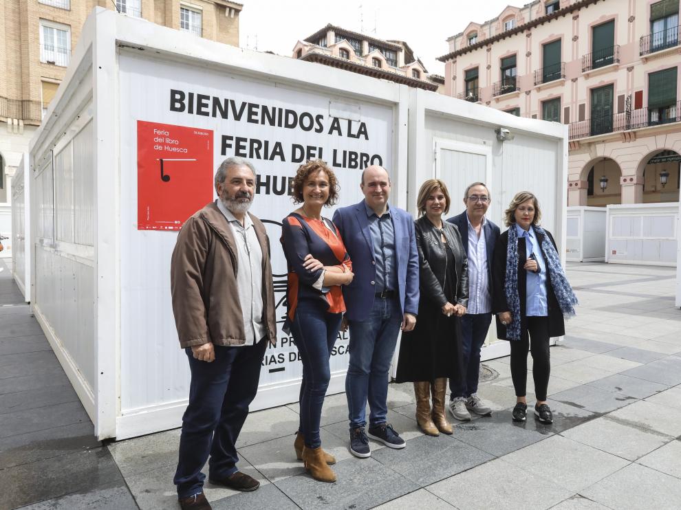 Representantes de la Asociación Provincial de Librerías, del Gobierno de Aragón, del Ayuntamiento de Huesca y de la Comarca de la Hoya, junto a las casetas de la feria.