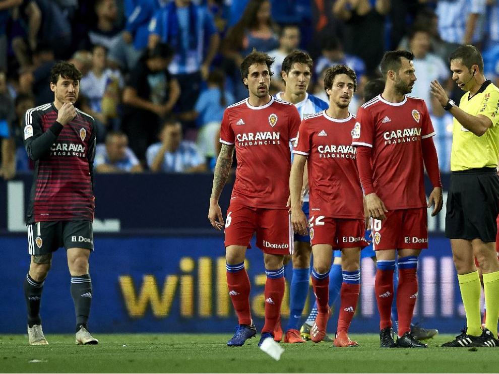 Cristian Álvarez, Eguaras, Delmás y Guitián, junto al árbitro Trujillo Suárez, en el momento de la conclusión del último partido del Real Zaragoza, en Málaga el pasado viernes, con derrota por 3-1.