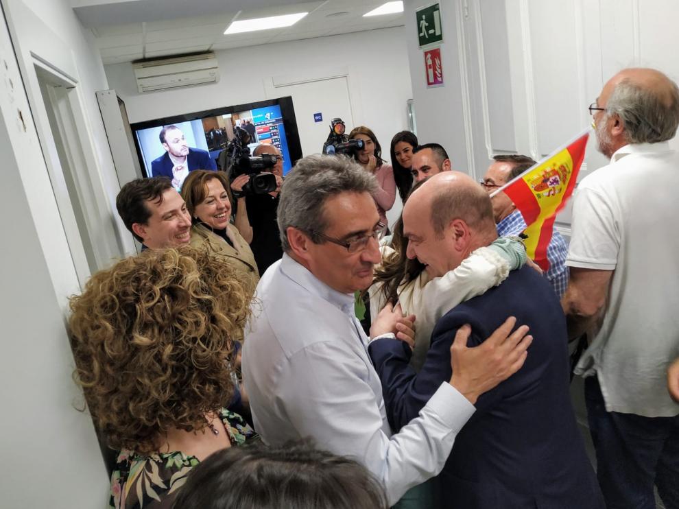 El líder de Vox en Aragón, Santiago Morón, se funde en un abrazo con una militante, al paso del nuevo concejal del partido en Zaragoza, Julio Calvo.