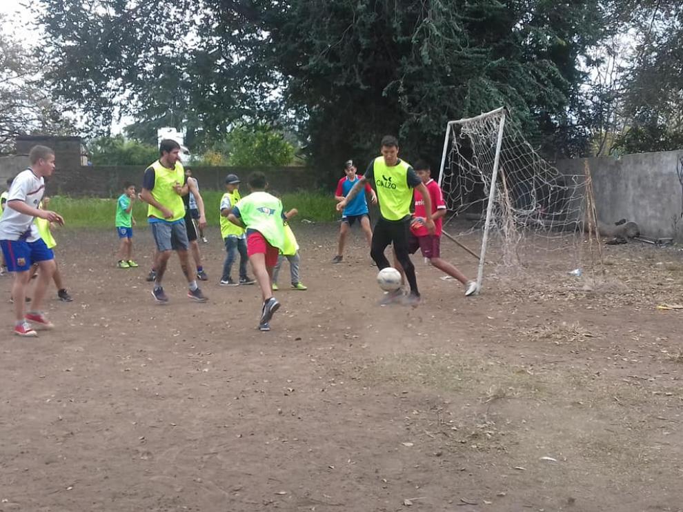 Damián Musto, jugando con los niños en el potrero de Casilda.
