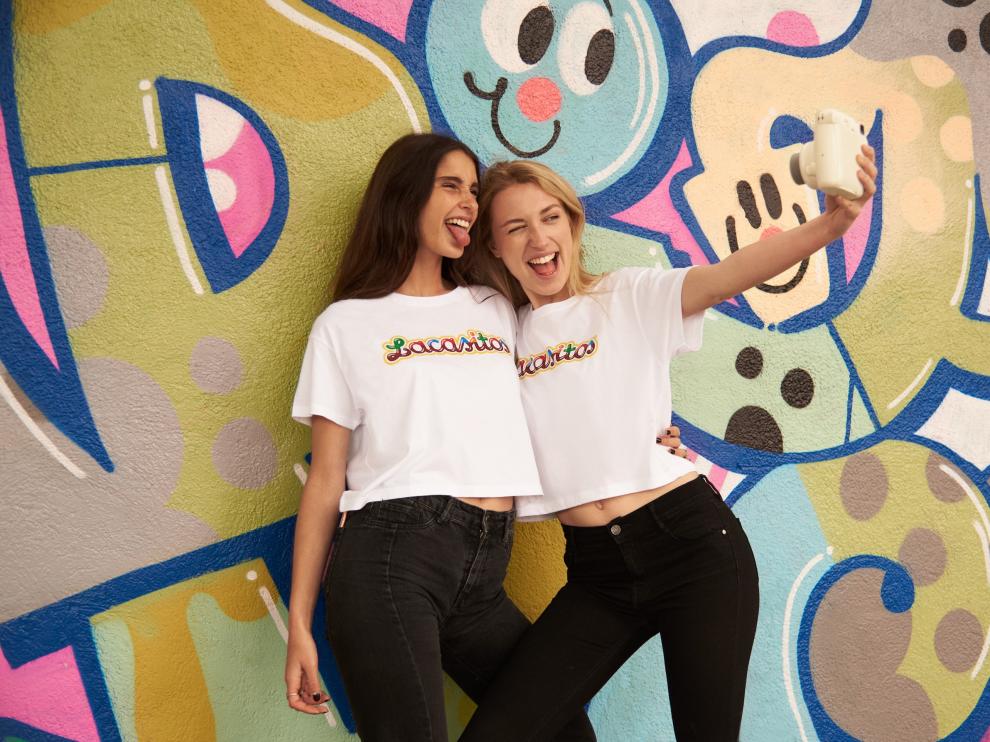 Dos jóvenes se realizan un selfie con la nueva camiseta de Lacasitos que comercializa Pull&Bear