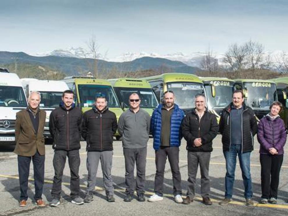 Conductores de la agencia de viajes con sus vehículos al fondo.