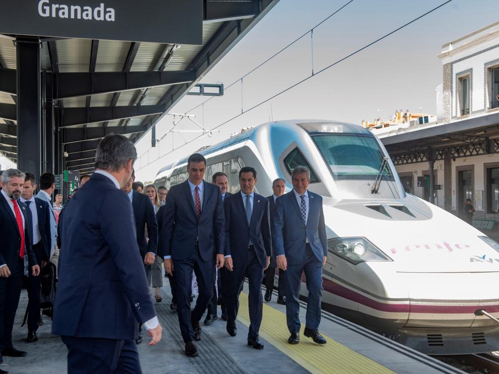 El presidente del Gobierno en funciones, Pedro Sánchez, y el líder del Ejecutivo andaluz, Juanma Moreno, caminan por la estación granadina tras llegar a bordo del primer AVE Madrid-Antequera-Granada.