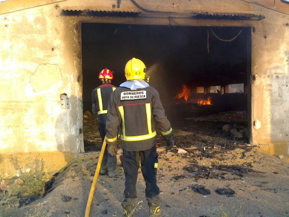Bomberos en una de las naves agrícolas afectadas por el fuego.