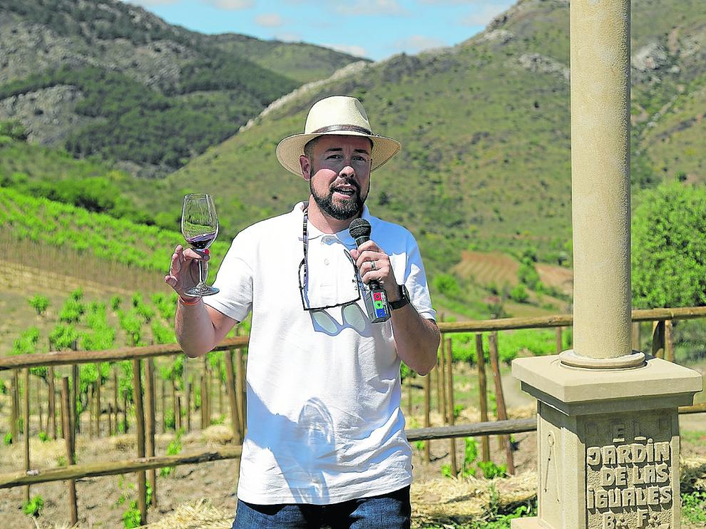 Fernando Mora, con una copa junto al peirón instalado en la finca que da nombre al vino, El Jardín de las Iguales.