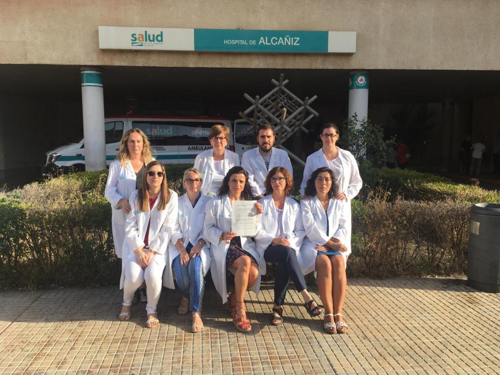 Auxiliares administrativos del Salud posan ante el Hospital de Alcañiz con la queja que han presentado ante el Justicia