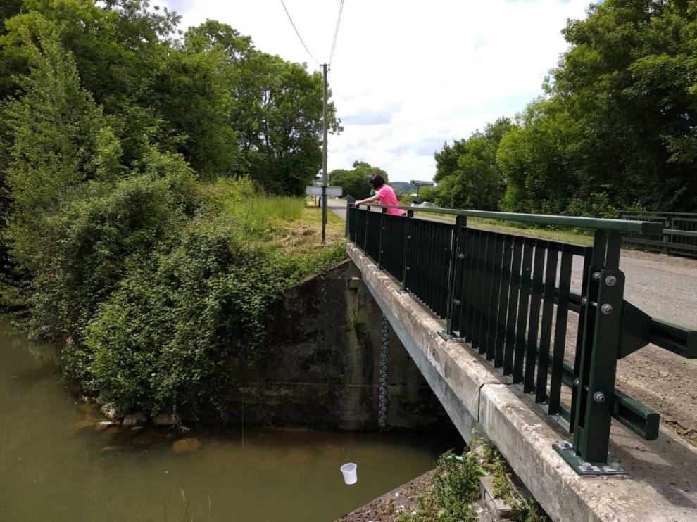Una investigadora recoge muestras de agua en el río Gabas en las Landas francesas.