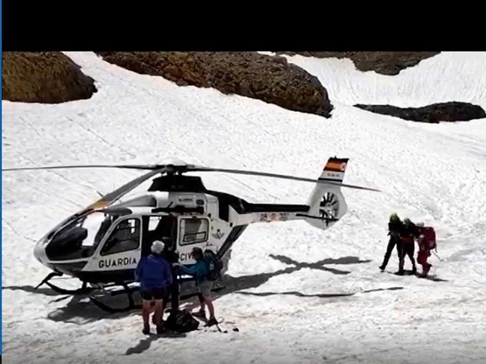 Los especialistas de Panticosa ayudan al montañero francés a llegar al helicóptero.