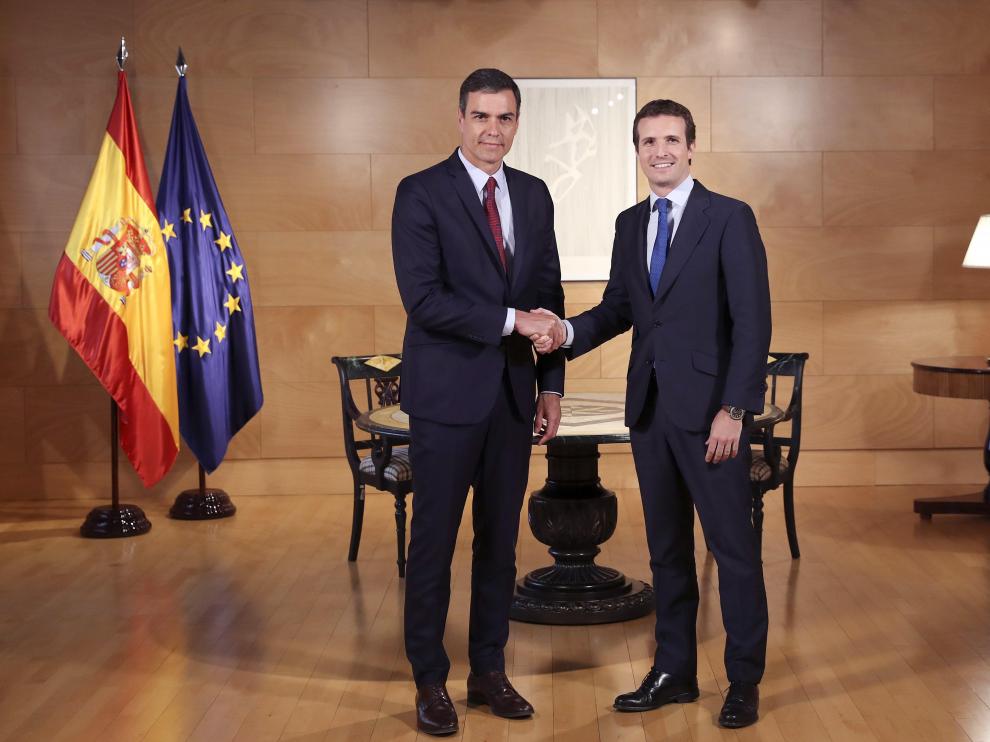 Pedro Sánchez y Pablo Casado se estrechan la mano.