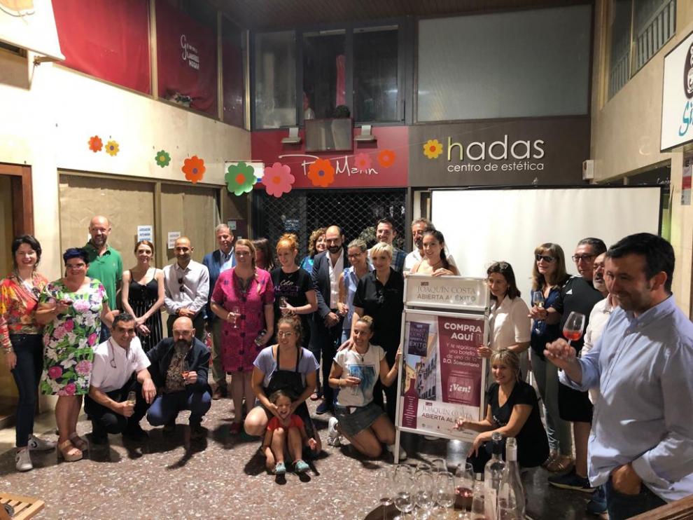 Miembros de la corporación municipal, del comercio y del sector del vino con comercios de la calle.