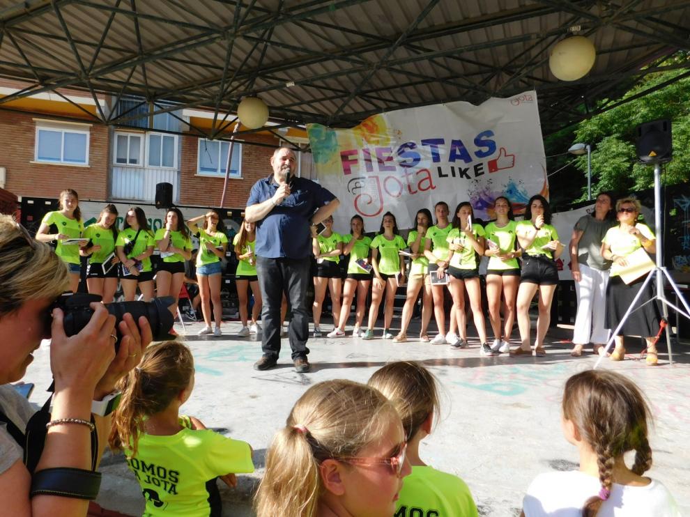 Foto de un acto de las fiestas en el que puede verse la pancarta al fondo