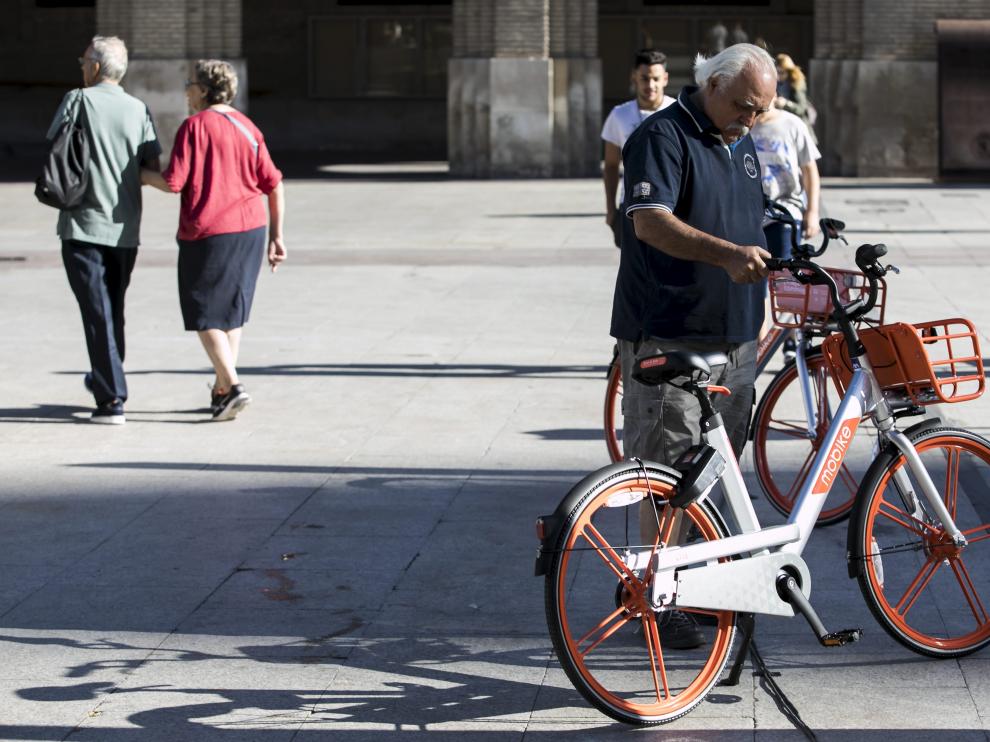 Un usuario de las bicicletas de Mobike, en la plaza del Pilar de Zaragoza.