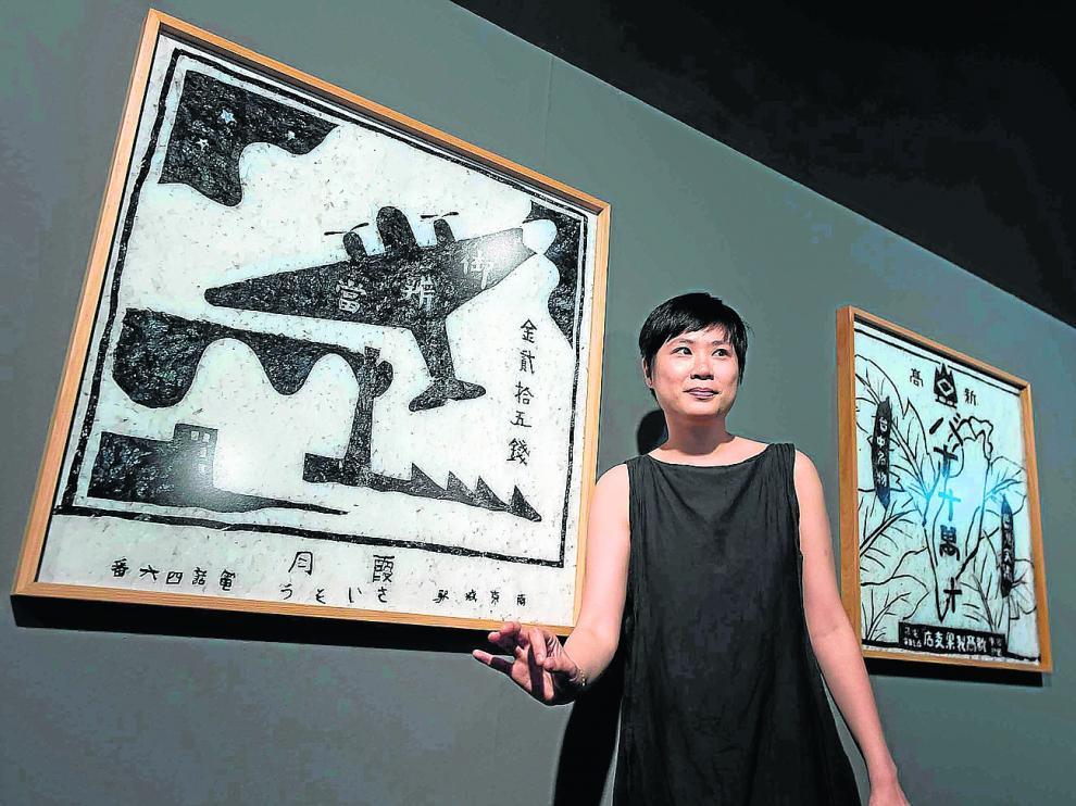 La artista Hoy I-Ting posa delante de varias piezas de la exposición ‘Tejiendo identidades’.