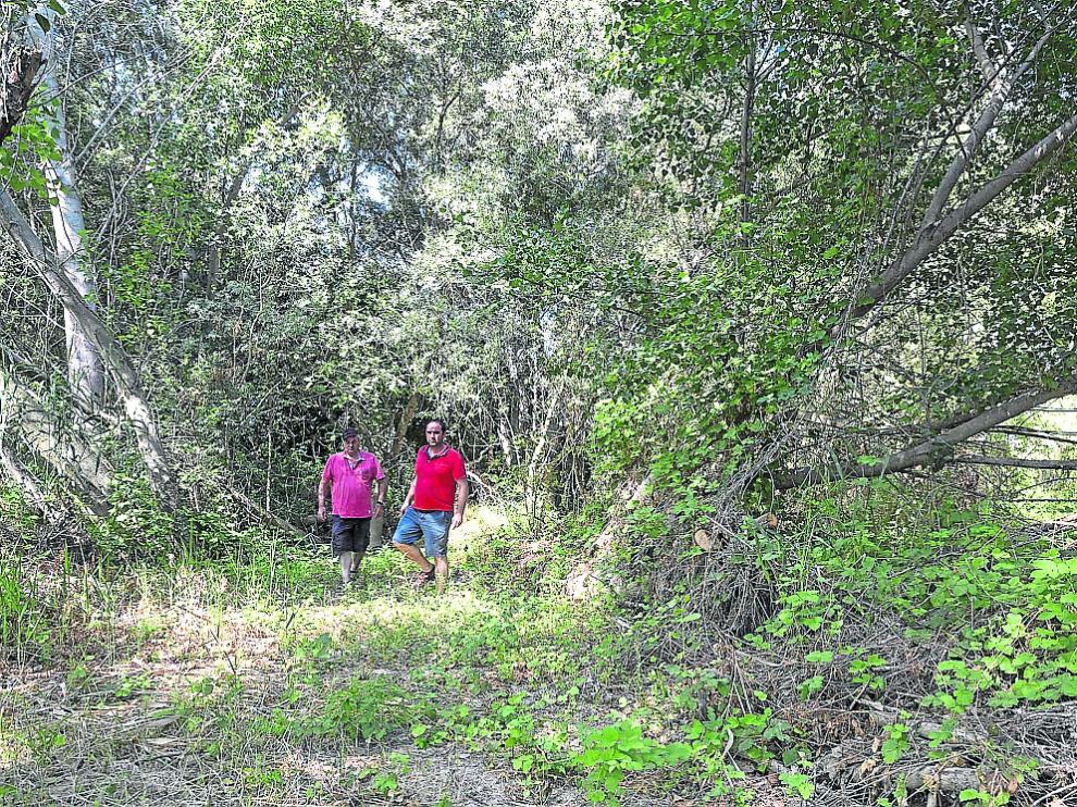 Raúl Moncín –derecha–, actual alcalde de Pradilla, junto a su padre y anterior alcalde, Luis Eduardo Moncín, en la ribera del pueblo, donde se realizarán tareas de limpieza a partir de este lunes.