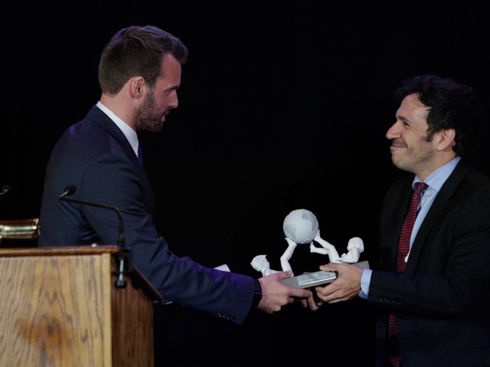 El representante de HBO, David Coupland, recibe un galardón de parte de José Antonio Gil, durante la entrega de premios de 'Amigos de España'.