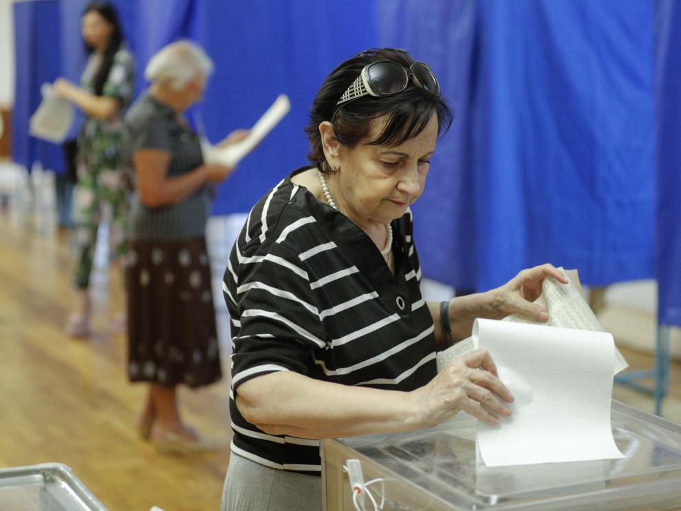 Una mujer deposita su voto en las elecciones al parlamento de Ucrania.