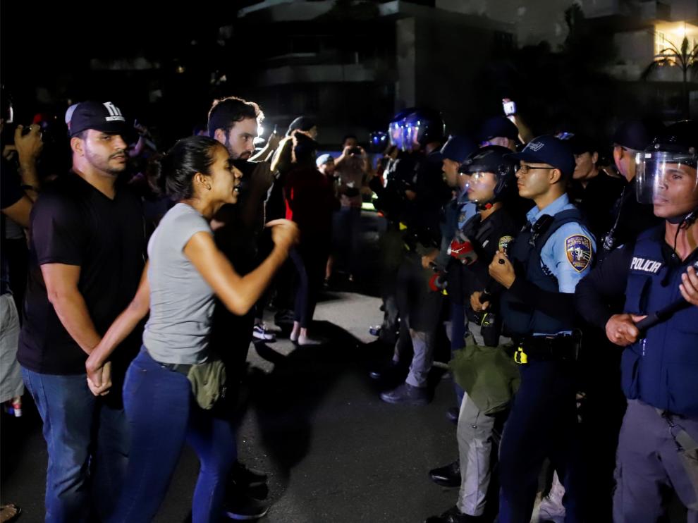Manifestantes se enfrentan a la policía mientras el gobernador Ricardo Roselló mantiene una reunión con alcaldes federados.