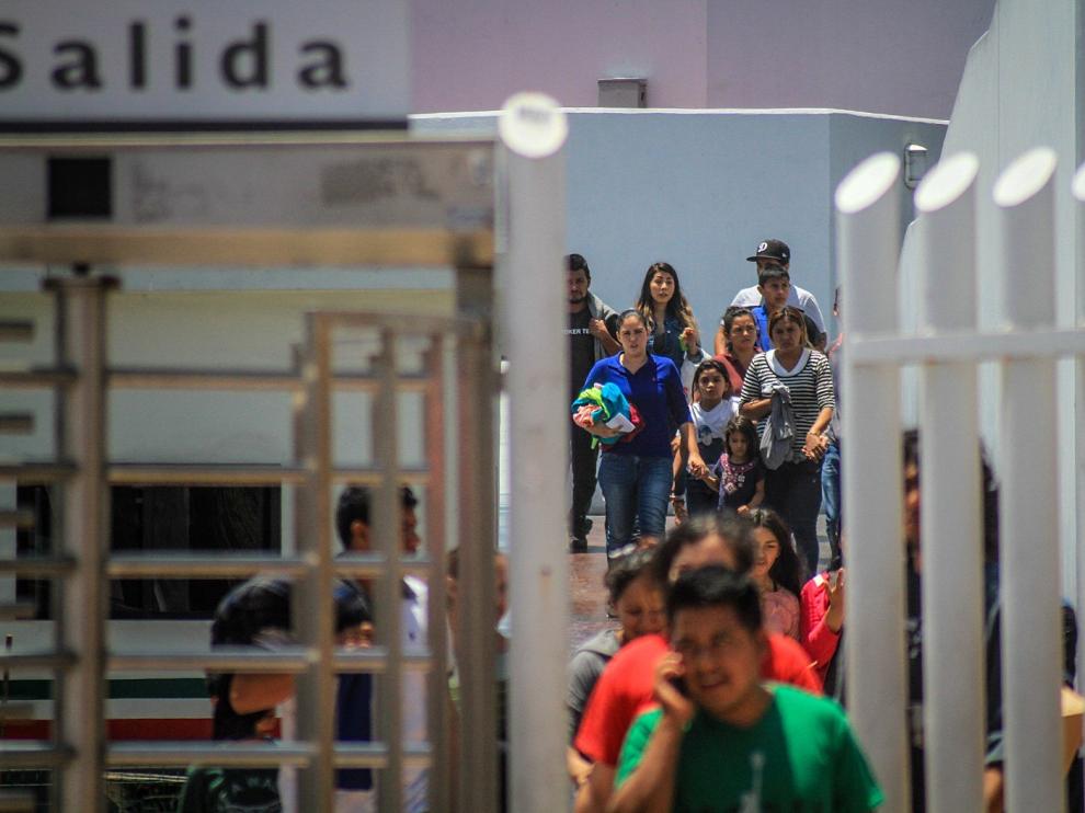Decenas de inmigrantes retornan este martes a México por la garita del chaparral, en la ciudad de Tijuana.