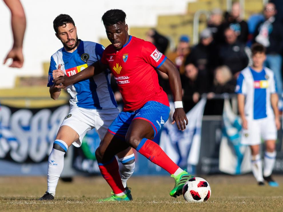 Un jugador del CD Teruel protege el balón ante la presión de un futbolista del Hércules.