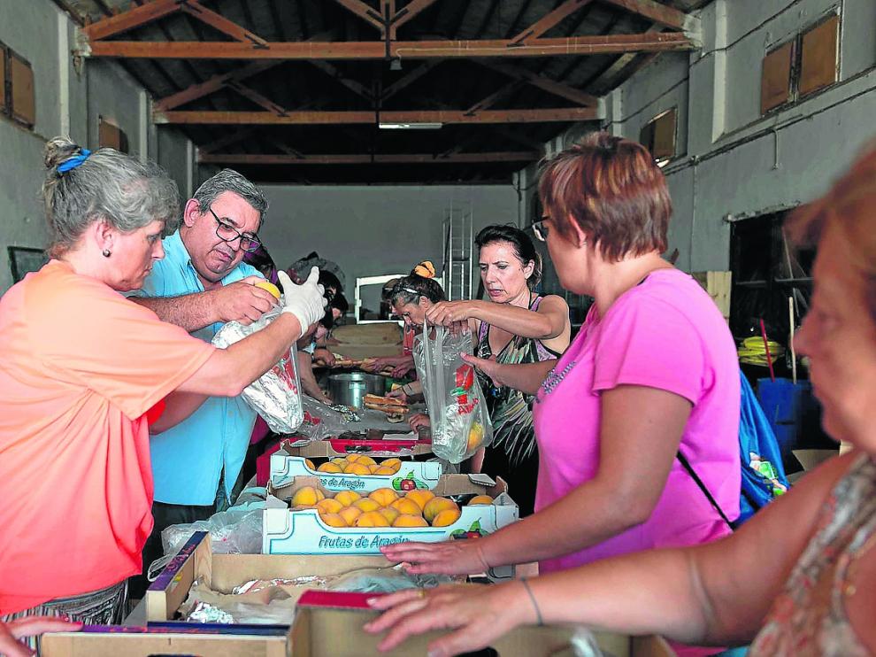 Varios vecinos preparan bolsas con comida y bebida para el operativo de extinción.