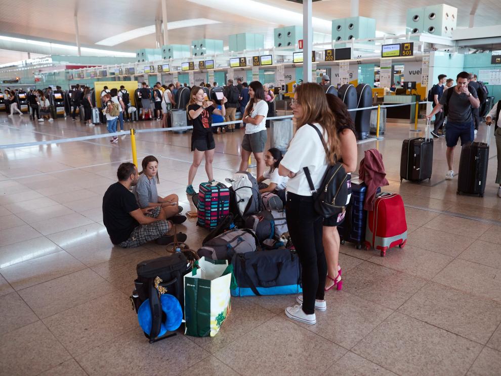 arias personas esperan este sábado frente los mostradores de la aerolínea Vueling