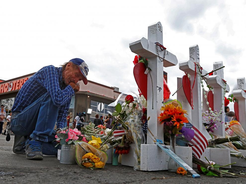 Antonio Basbo, un familiar de una de las víctimas del tiroteo en El Paso, se arrodilla frente al memorial en honor a los 22 fallecidos.