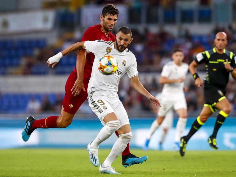 Benzema intenta marcharse del jugador de la Roma Fazio.