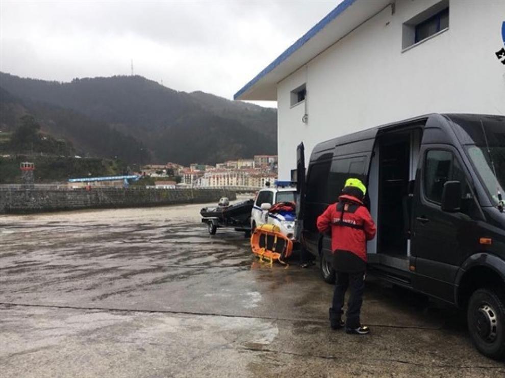 Personal de la Ertzaintza junto con una camilla y coche de la Institución.