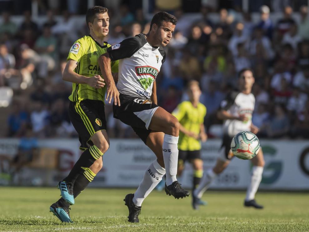 Soro pugna con el jugador del Tudelano Lalaguna en un lance del partido de este sábado en Tudela, donde el Real Zaragoza perdió 1-0.