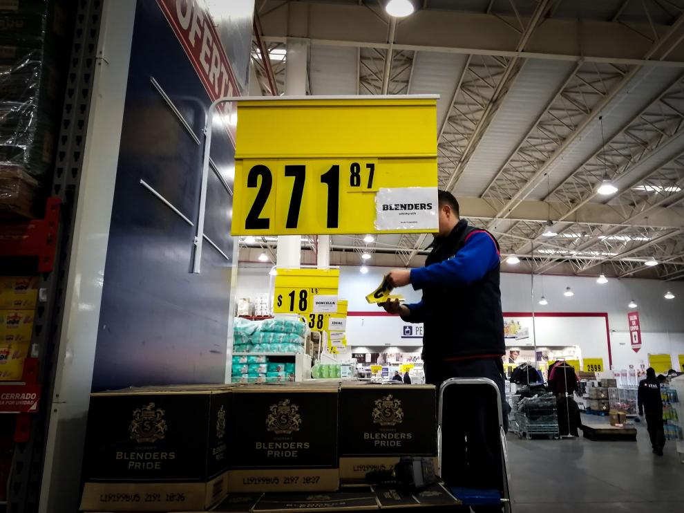 Un empleado cambia los precios ante la incierta situación económica argentina.