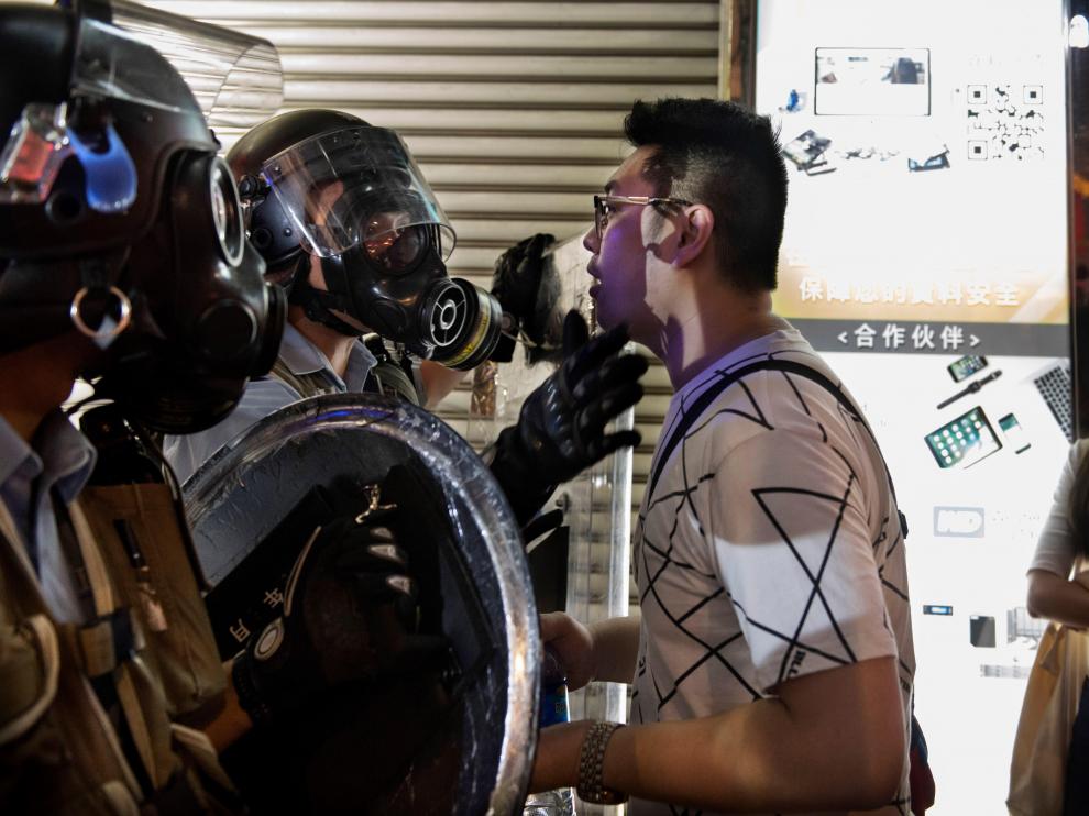 Hong Kong (China), 14/08/2019.- A man stands in front of a policeman as protesters attend an anti-government rally in Sham Shui Po, Hong Kong, China, 14 August 2019. Hong Kong has been engulfed in protests since early June, at first to oppose the now-suspended extradition bill that would have allowed Hong Kong to send suspects to mainland China. The protests have developed into an anti-government movement. (Protestas) EFE/EPA/MIGUEL CANDELA Anti-government protesters rally in Sham Shui Po