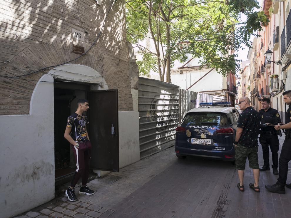 Dos policías nacionales y un vecino de la calle de Agustina de Aragón hablan con un joven okupa del edificio número 26.