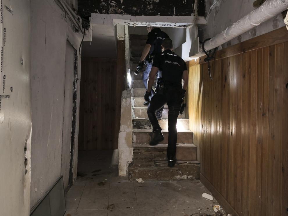 Dos agentes de la Policía Nacional inspeccionan el edificio okupa del número 26 de la calle de Agustina de Aragón.