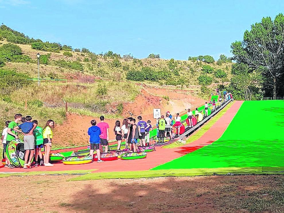 La pista de esquí sintética de Alcalá de la Selva y, a la izquierda, el tobogán para colchonetas.