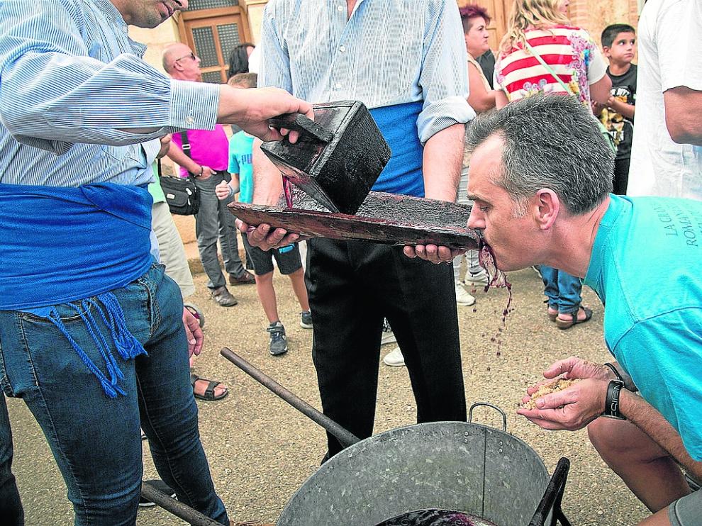 Un vecino bebe vino de la teja más antigua del pueblo mientras sostiene en sus manos las migas.