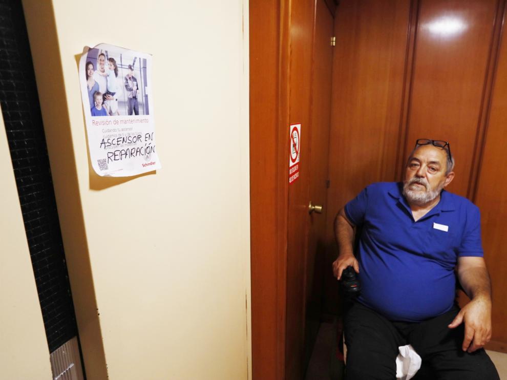 Jesús Luis Domínguez junto al cartel del ascensor estropeado en su edificio