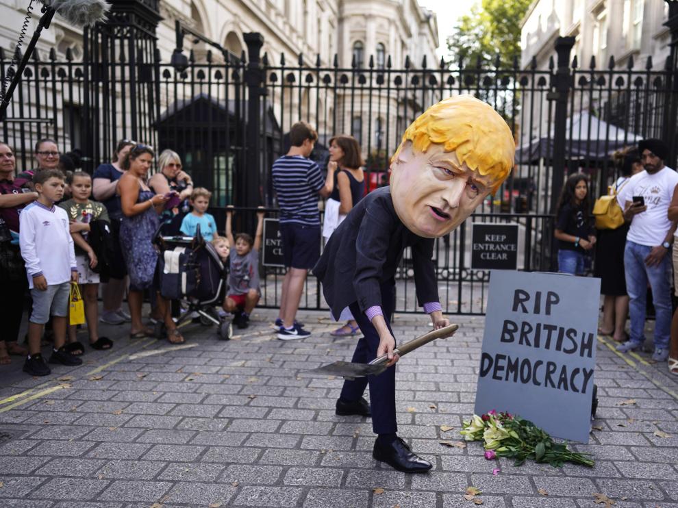Un ciudadano con una careta de Boris Johnson escenifica la muerte de la democracia británica