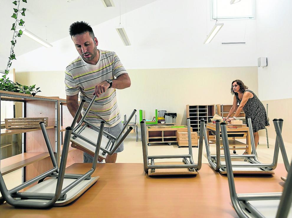 Dos docentes del colegio integrado Arcosur instalan el mobiliario en uno de los ambientes que ocupan los alumnos de infantil. El centro trabaja pedagogías vivas y activas en las que los más pequeños deciden en algunos momentos de la jornada lectiva en qué estancias quieren estar.