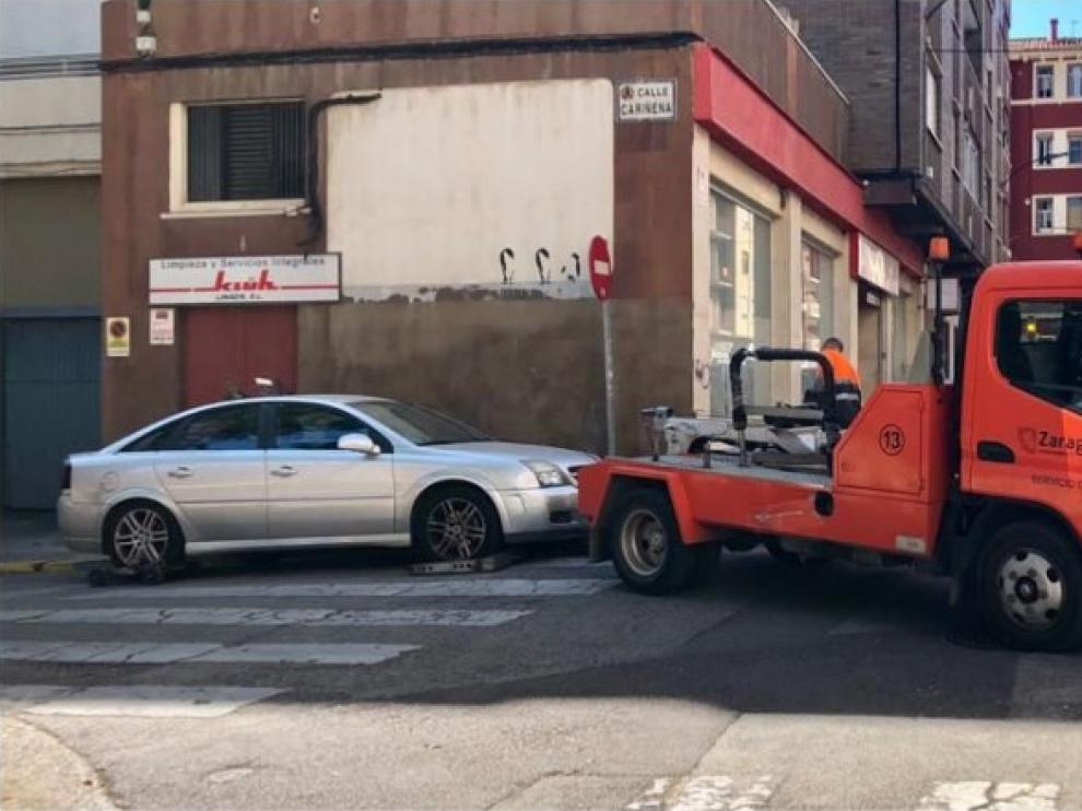 La grúa municipal retirando un coche mal aparcado en las Delicias.