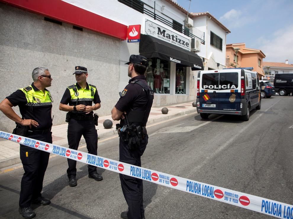 Efectivos de la Policía Nacional y Local controlan la zona junto al cadáver de la mujer de 81 años que ha sido encontrada muerta en la barriada del Puerto de la Torre, en Málaga
