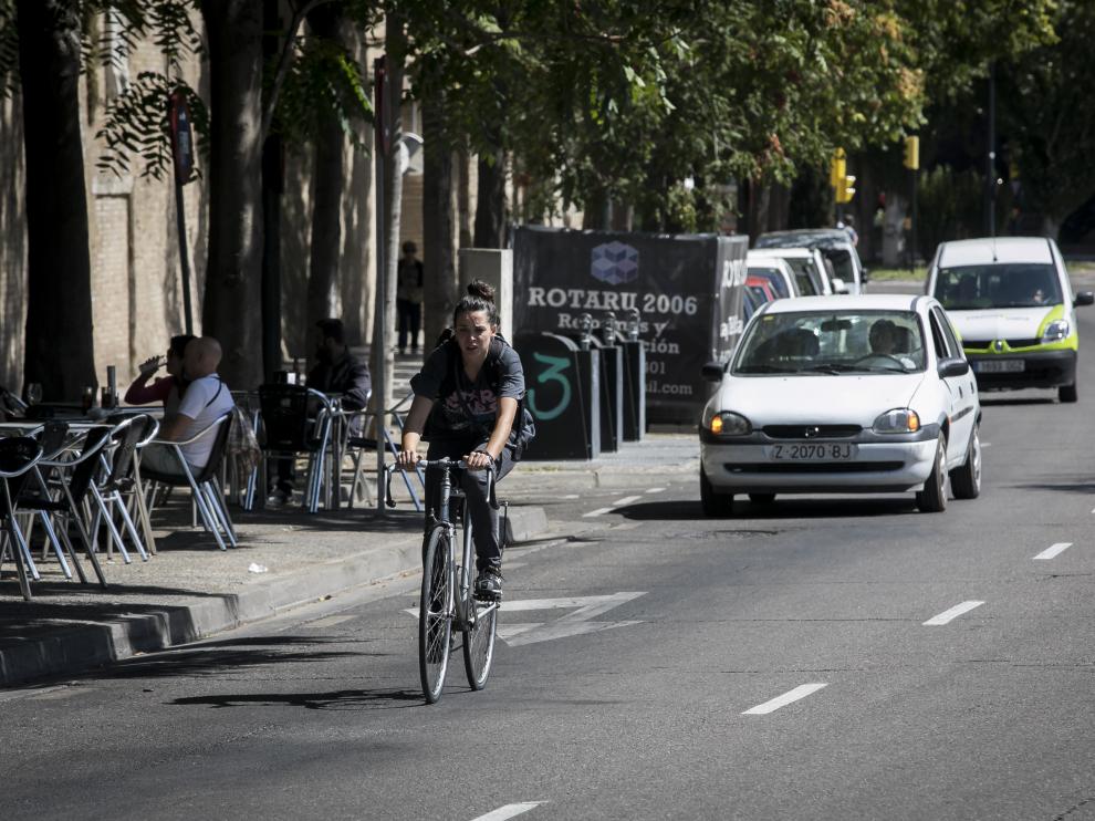 Una ciclista circula entre coches por la calle Asalto.
