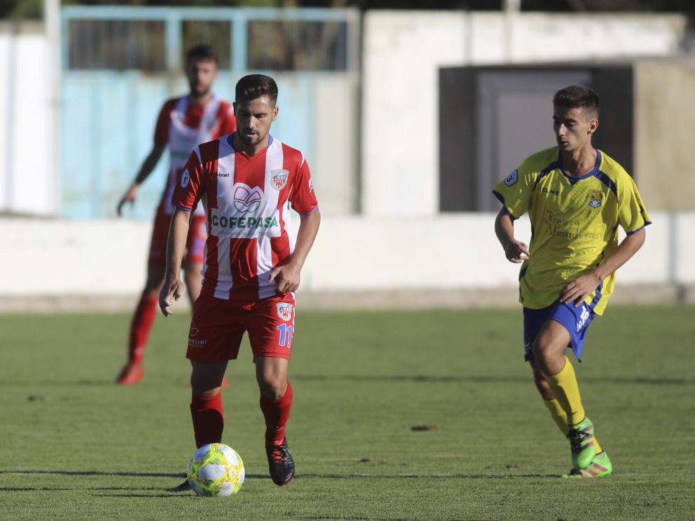 Un jugador del Monzón conduce ante la presión de un rival del Almudévar.