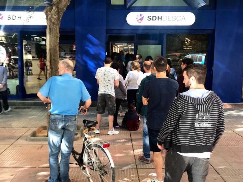 Filas de aficionados frente a las oficinas de la SD Huesca.