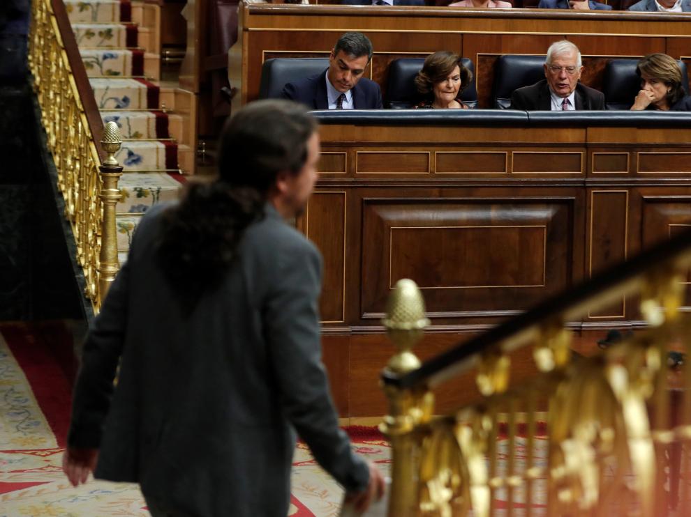 El líder de Unidas Podemos, Pablo Iglesias, pasa ante los miembros del Gobierno Pedro Sánchez (4d), Carmen Calvo (3d) y los ministros Josep Borrell (2d) y Dolores Delgado (d)
