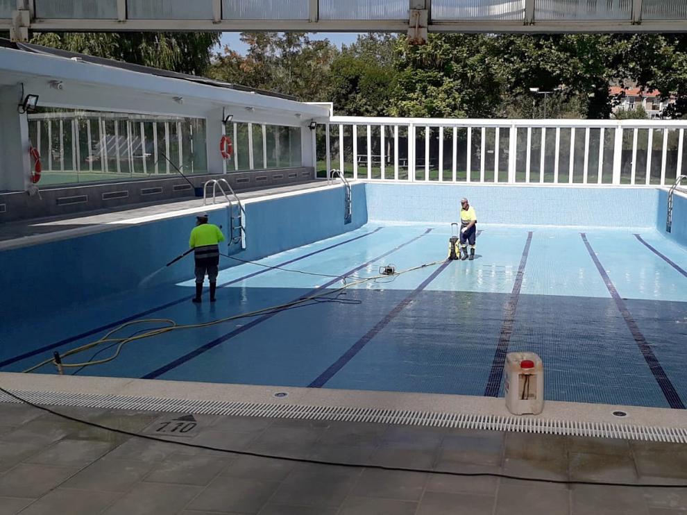 Operarios preparan la piscina climatizada para su inminente apertura