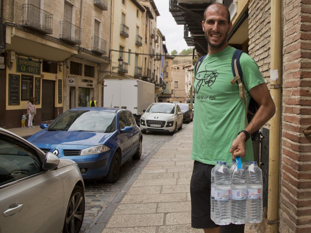 Un vecino, con seis botellas de agua que adquirió en Daroca.