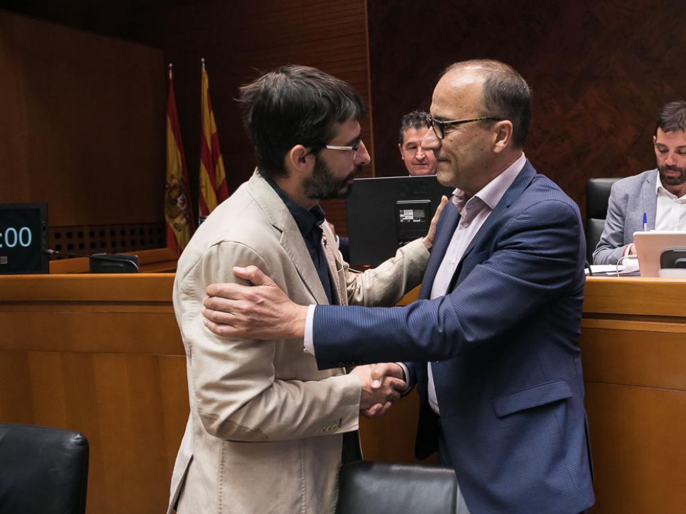 Felipe Faci, a .la derecha, saluda a un miembro de la comisión de Educación de las Cortes ante la que ha comparecido este martes.