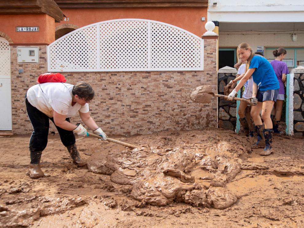Vecinos de Los Nietos, en Cartagena, limpiando el barro que dejó el temporal de lluvia